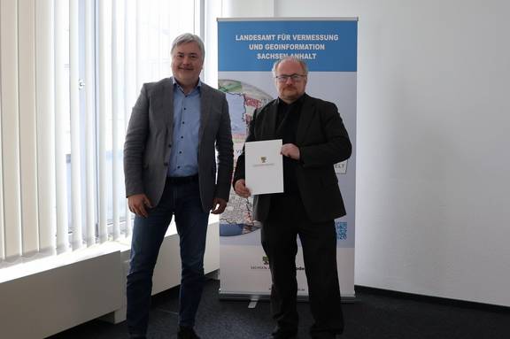 Herr Volker Galle (stellv. Behördenleiter) übergibt Herrn Dipl.-Ing. Bernhard Römmer die Bestallungsurkunde